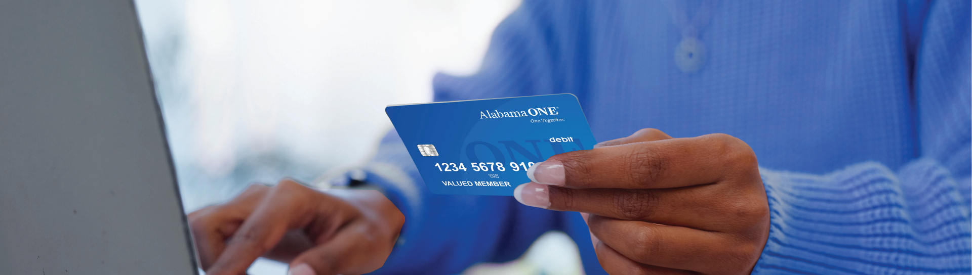 woman holding an Alabama ONE blue debit card