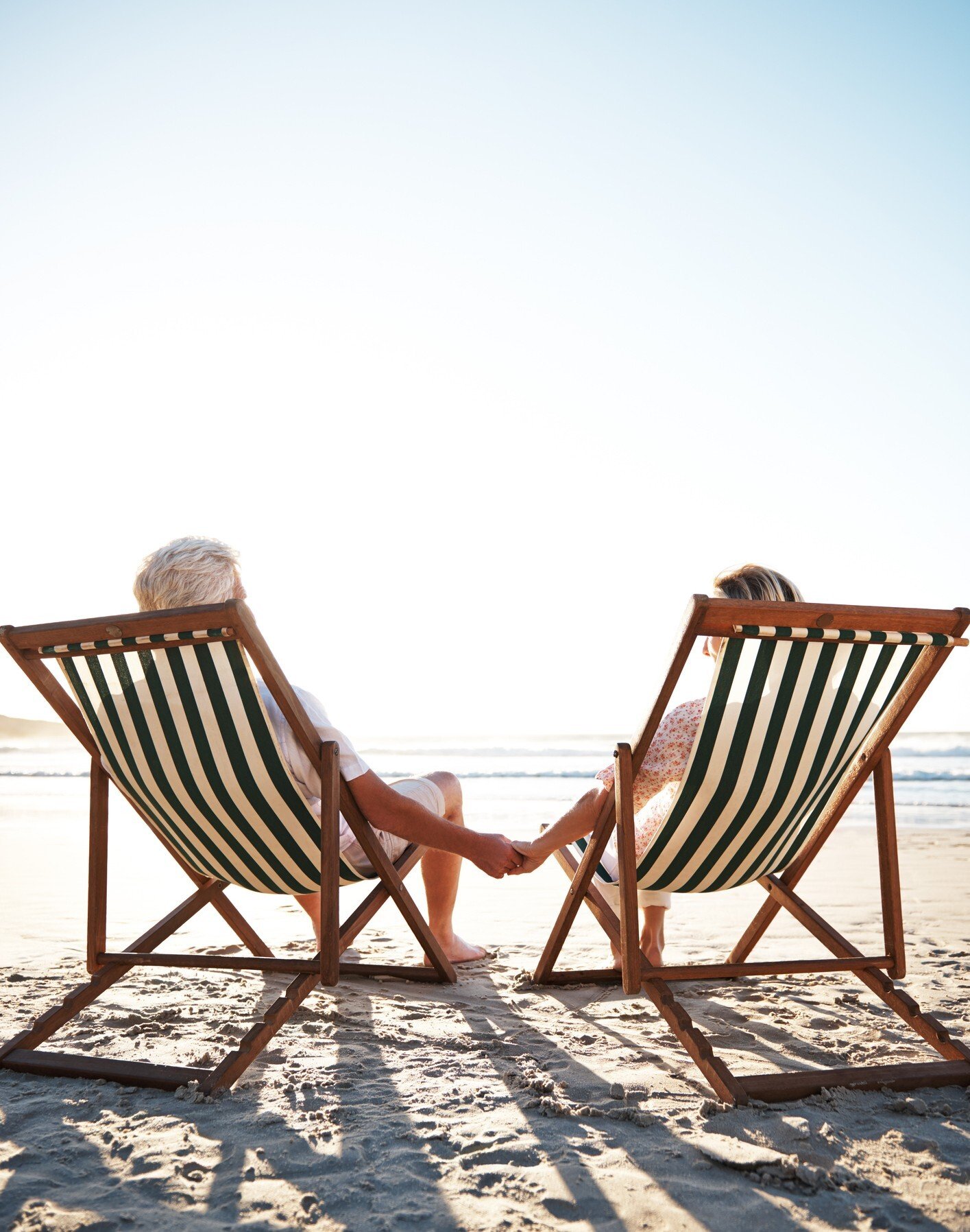 elderly couple lounging in the sand