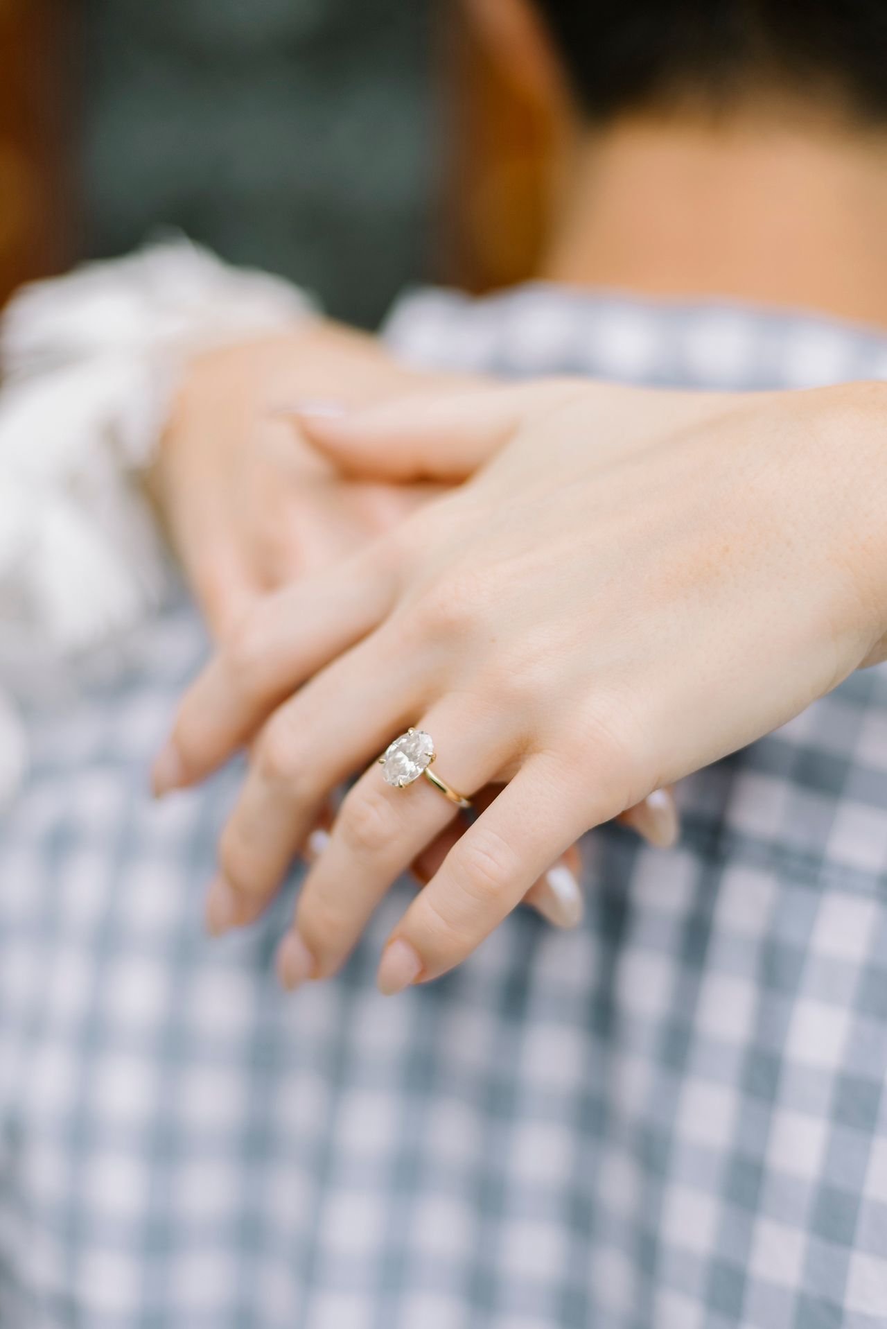 women's hand with ring resting on man's back