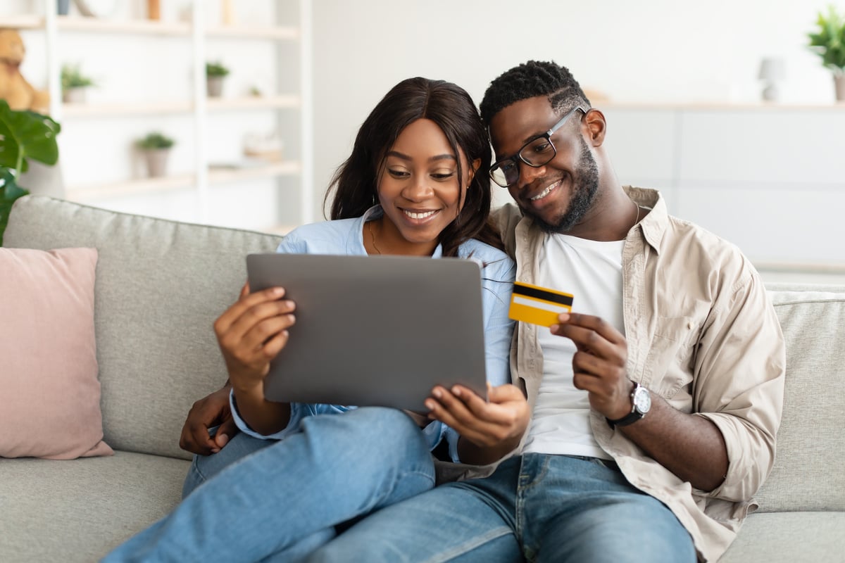 black-couple-using-pc-and-debit-credit-card-at-hom-2022-10-07-01-25-37-utc