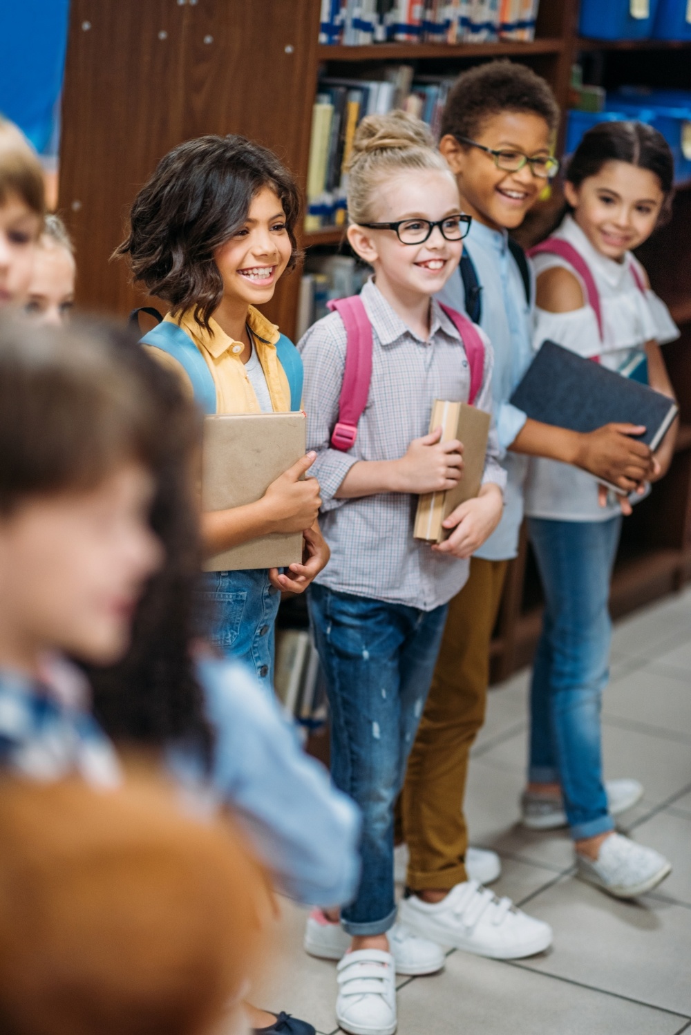 cute-kids-in-library-standing-in-row-with-books-2023-11-27-05-26-09-utc